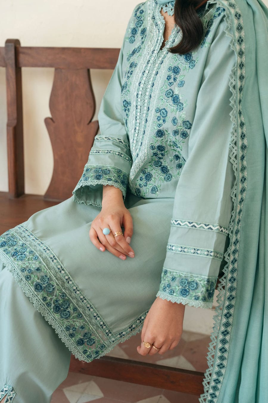 Three-piece unstitched heavy embroidered lawn suit with four-sided embroidered dupatta by Shaa Posh, displayed on a hanger.